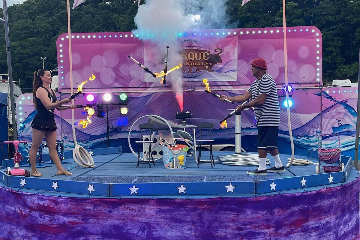 Circus Performers Juggling Sticks with Fire