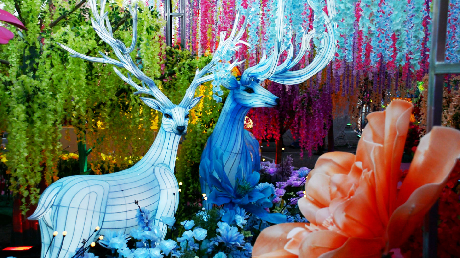 Two magical creatures with horns in a forest of flowers