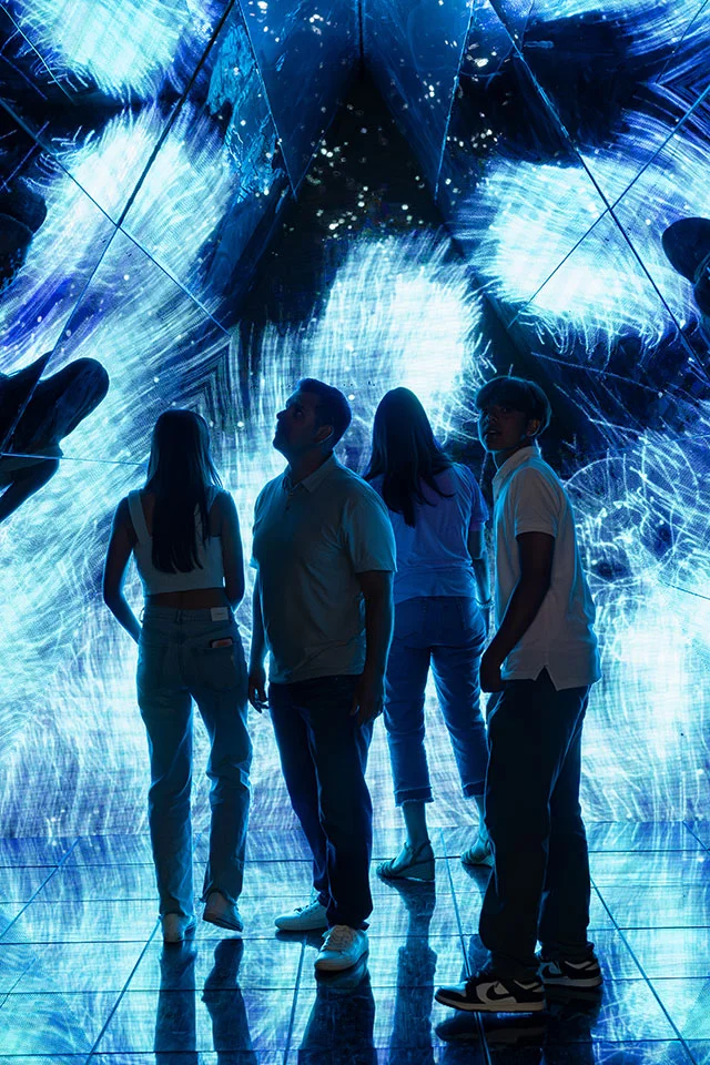 Family in a blue mirror room at Imaginarium