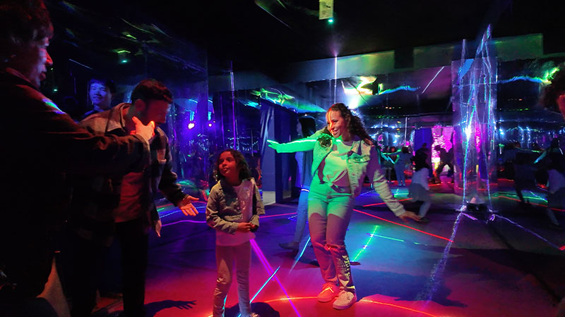 Imaginarium Let's Glow Crazy – Family has a dance party and takes photo in a laser light room.
