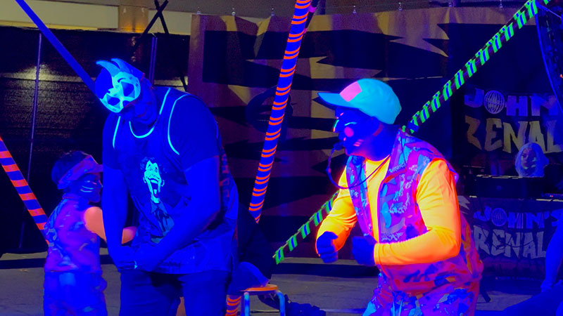 Imaginarium Let's Glow Crazy – The Neon Circus, clown engages with an Imaginarium guest.